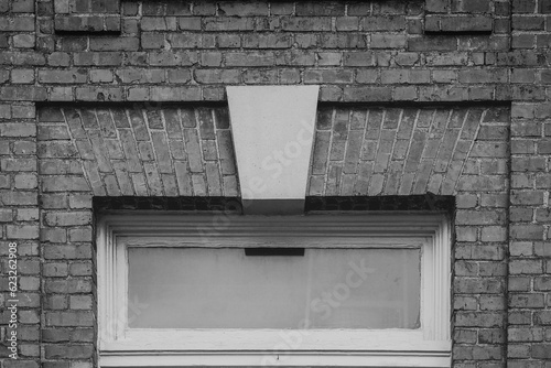Old transom window and solid brick in monochrome