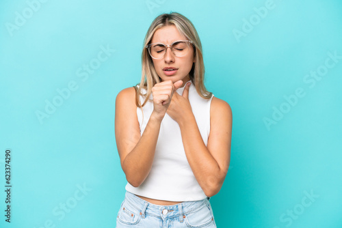 Young caucasian woman isolated on blue background coughing a lot