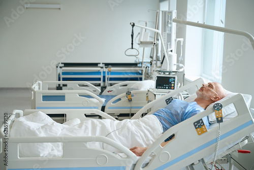 Man lying on the bed in intensive care unit