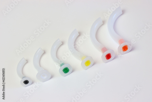 Oropharyngeal airway cannula in a white surface aligned by the size of each cannula. Small to big size. 0 to 5 size of a guedel cannula 