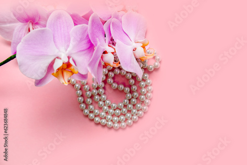 Pearl necklace and Purple orchid on pink background 