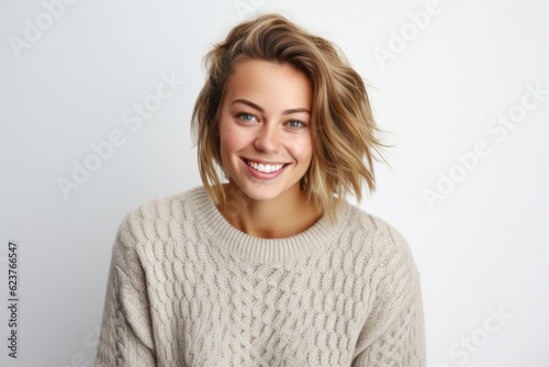 Portrait of a beautiful young woman with blond hair smiling against white background