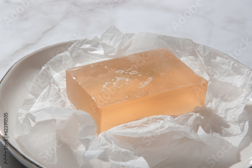 Natural bar soap for healthy skin and hair. Hydrating cleansing bar on crumpled package paper