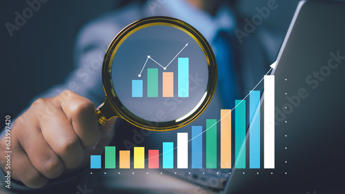 Businessman using magnifying glass searching data goal business success strategy chart target and planning Stock market, Business growth. Stock market graph financial profit stock market development.
