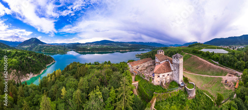  most famous and beautiful medieval castles of northern Italy. scenic Cles castel- in Trentino , province of Trento. surrouded by fields of apple trees near the lake Santa Giustina