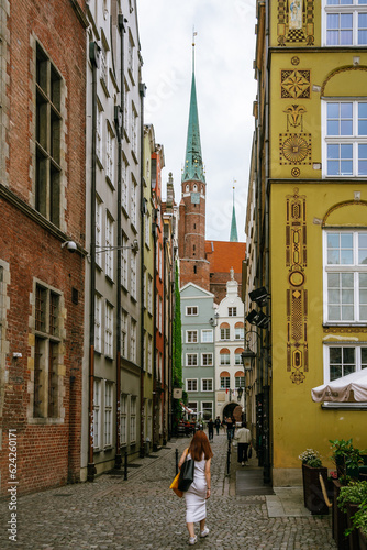Woman walking up a lane in the old town of Gdańsk, Poland