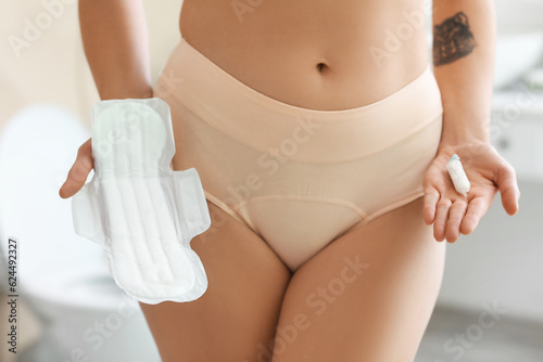 Young woman in period panties with menstrual pad and tampon at home, closeup