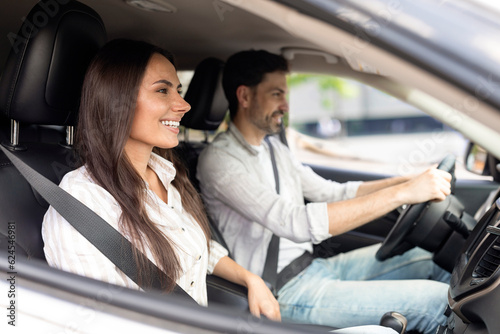 Cheerful millennial couple test drive new auto together