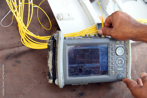Technician working, fiber optic cable splicing and testing cables with optical power meter 