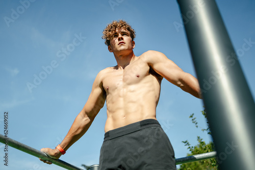 Strong young sportsman doing calisthenics