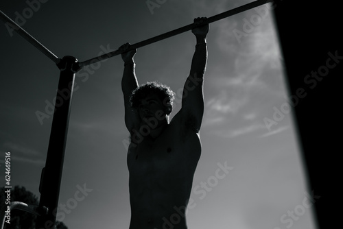 Strong young sportsman doing calisthenics