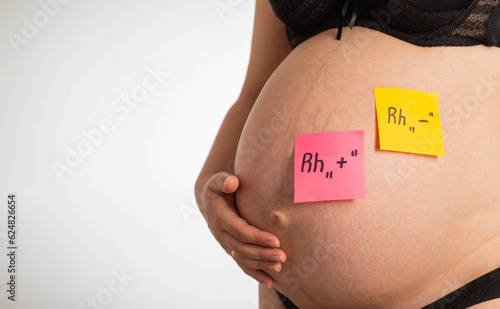 Stickers on the belly of a pregnant girl with inscriptions negative and positive Rh factor. Rh factor compatibility concept, Rh conflict. Copy space for text