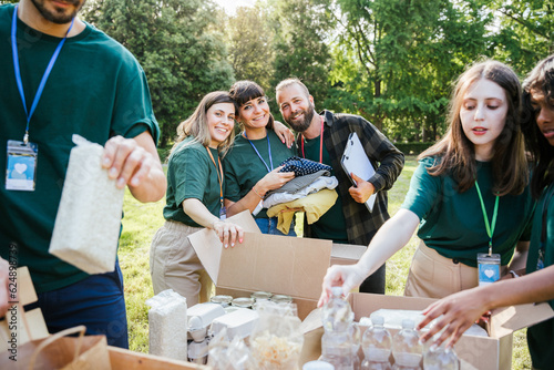 Portrait of a group of volunteers on a day of collection and distribution of clothes and food for people in need - Concept of solidarity and humanitarian aid - Copy space