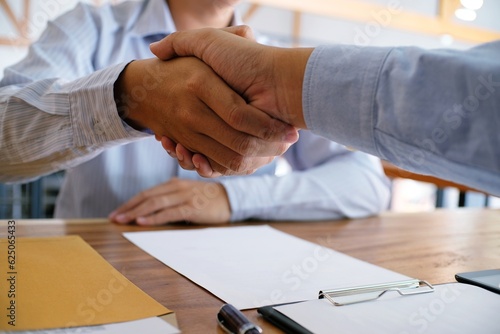 Image business mans handshake after signing contract making a deal. Business partnership meeting concept.