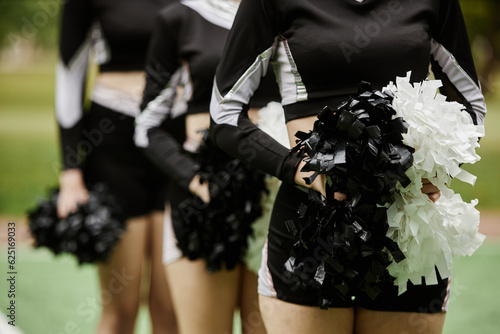 Close-up of group of cheerleading women dancing with pompom outdoors
