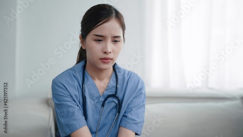 Tired depressed young asian woman nurse suffer after hard working. Exhausted sad woman doctor feels burnout stress. Physician burnout