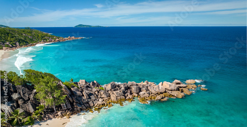 Aerial view of famous Grand Anse beach with big granite rocks on the La Digue island, Seychelles. Tropical landscape with sunny sky.