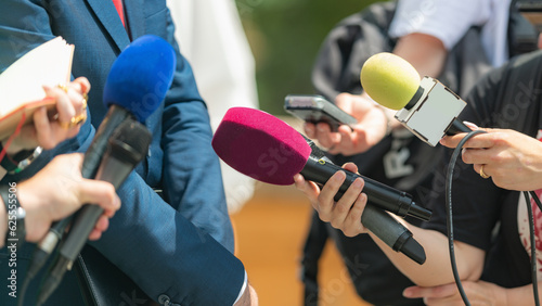 Media coverage as journalists with microphones gather at a press conference, delivering informative insights and capturing the essence of the event 