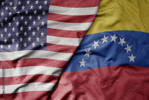 big waving colorful flag of united states of america and national flag of venezuela .