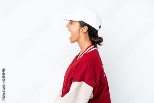 Young hispanic woman wearing a baseball uniform isolated on white background laughing in lateral position