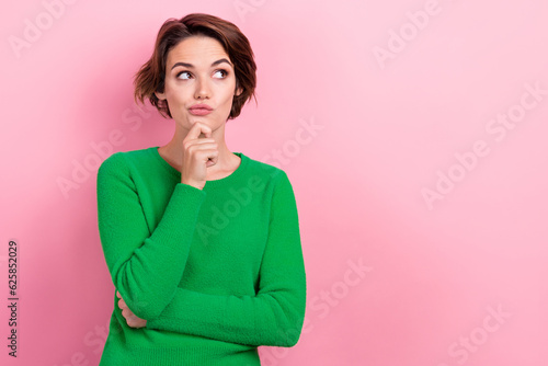 Portrait of thoughtful young girl hair wear green jumper touch chin ponder look empty space hmm idea isolated on pink color background