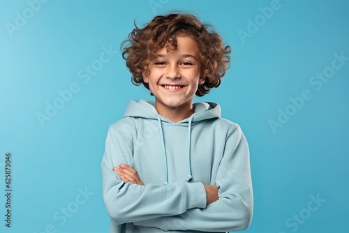 Portrait of a smiling little boy in a blue hoodie on a blue background