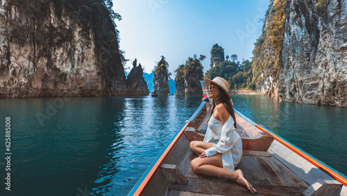 Traveler asian woman relax and travel on Thai longtail boat in Ratchaprapha Dam at Khao Sok National Park Surat Thani Thailand