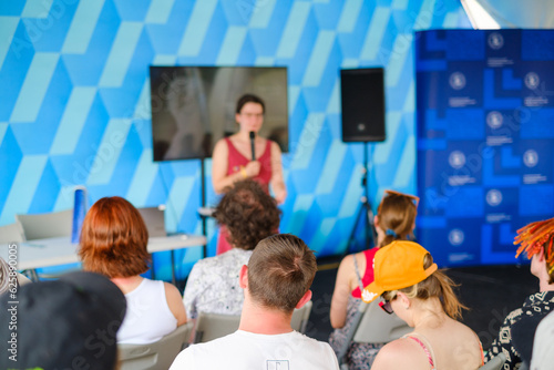 Woman speaking in front of audience on conference