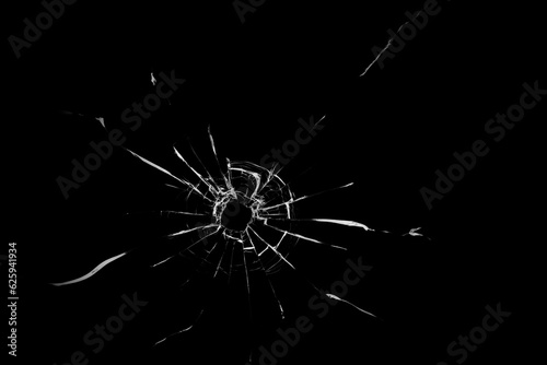 Texture of broken glass. Hole from a ball on a black background.