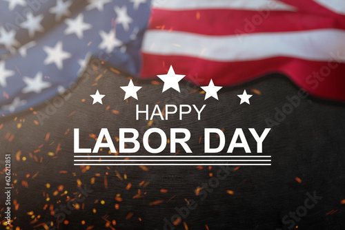 Happy Labor day concept. American flag with different construction tools on dark stone background, with copy space for text.