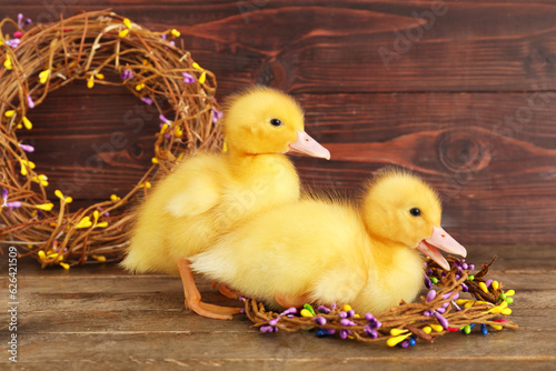 Cute ducklings and wreaths on wooden table