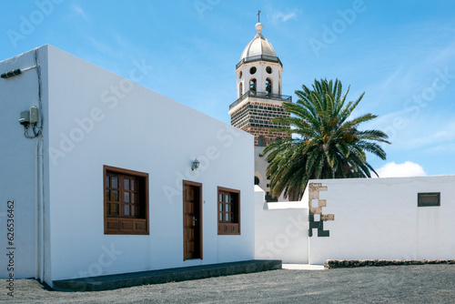 Traditional facade of a house in Teguise, with the church tower in the background.