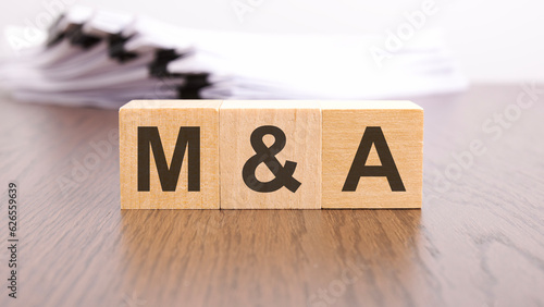 m and a letters on wood block cubes on wooden table, marketing concept