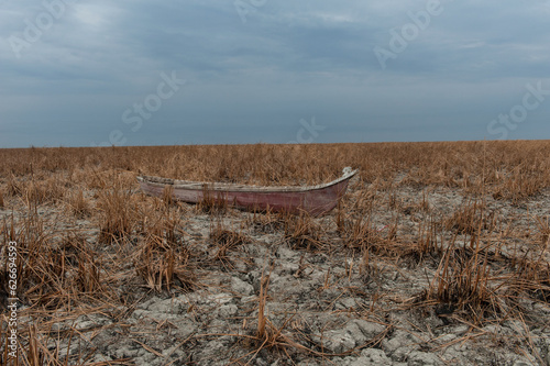 A traditional marsh boat abanodoned on dry marshland during a drought in the marshes of Southern Iraq. Climate change in the Middle East