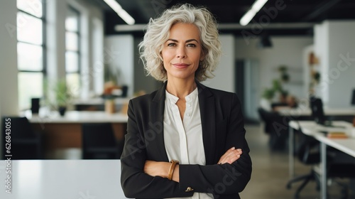 portrait of a senior business woman standing with arm crossed in office