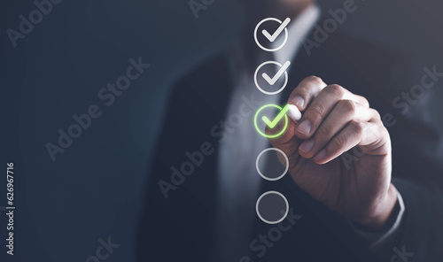 Businessman touching to tick correct sign mark in checkbox for quality document control checklist and business approve project concept.