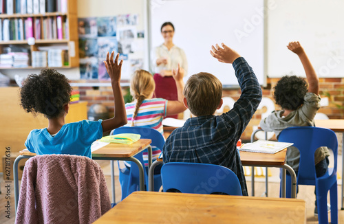 Education, question with group of children in classroom and raise their hands to answer. Learning or support, diversity and teacher teaching with young students in class of school building together