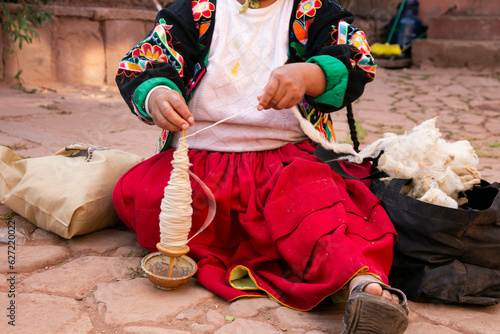Indigenous woman working on the elaboration of textile handicrafts in a community on Lake Titicaca, Peru.