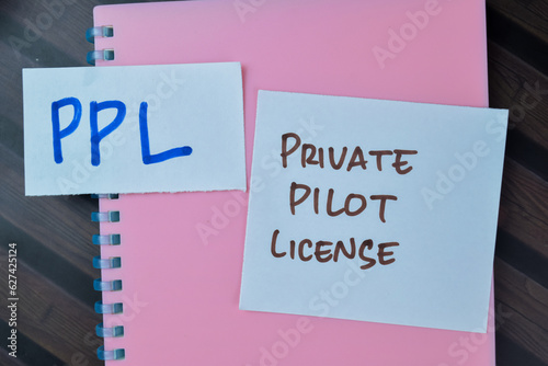 Concept of PPL - Private Pilot License write on sticky notes isolated on Wooden Table.