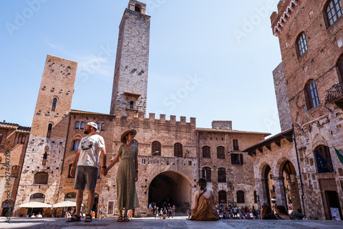 Beautiful traveler couple on the streets of San Gimignano, Italy