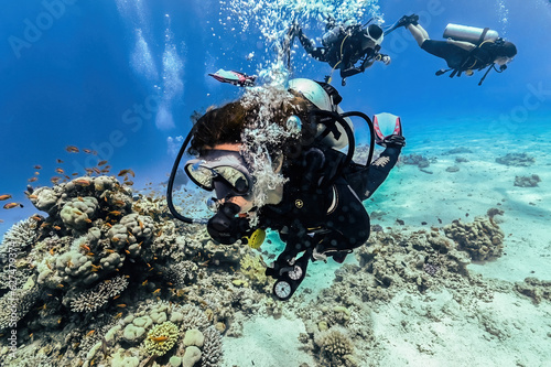 Woman diver portrait with corals on background in Egypt