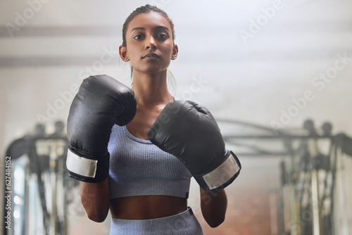 Fitness, gym or portrait of girl boxer in training, exercise or workout with a warrior mindset or wellness. Sports, motivation or healthy woman with speed, fast or powerful punch in boxing gloves