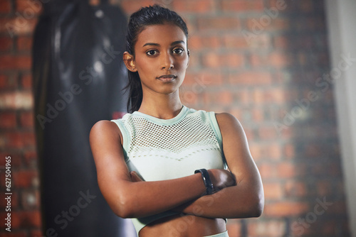 Woman, fitness and serious face in portrait with athlete in gym, arms crossed and determination with confidence. Mockup space, female person in exercise studio and active with health, sport and tough