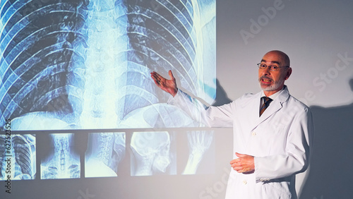 Middle aged Caucasian doctor presenting medical research using a projector screen.