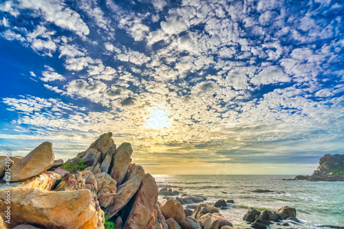 Dawn on the beach brightly colored clouds, beneath a rock with beautiful shapes create beautiful scenery welcome bright day fresh