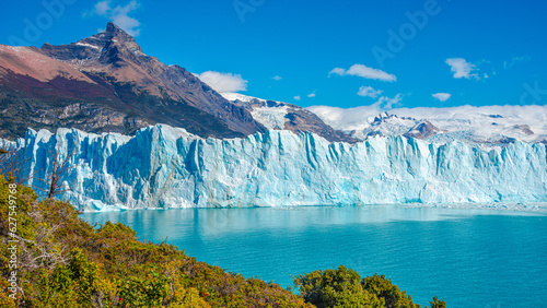 Panoramic over big Perito Moreno glacier in Patagonia with blue sky and turquoise water glacial lagoon, South America, Argentina, in Autumn colors