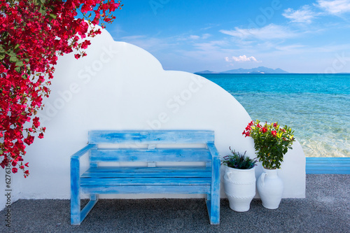 the colors of Greece with a bench in front of a wall and a view to the beautiful mediterranean sea