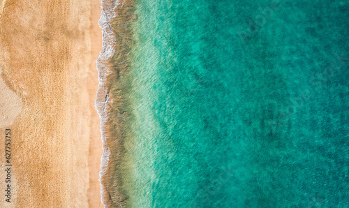 Beach with turquoise water on Fuerteventura island, Spain, Canary islands. Aerial view of sand beach, ocean texture background, top down view of beach by drone. Fuerteventura, Spain, Canary islands.