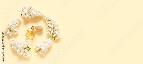 Frame made of white lilac flowers and bottle of perfume on light background with space for text
