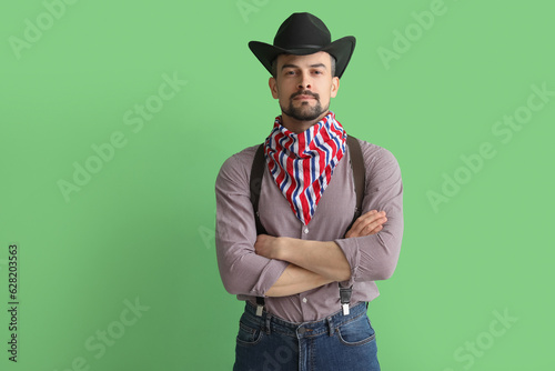 Handsome cowboy on green background